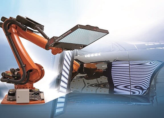 refelctocontrol sensor mounted on robot arm next to vehicle for paint inspection